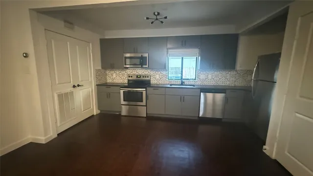 a kitchen with stainless steel appliances granite countertop a stove a sink and a refrigerator