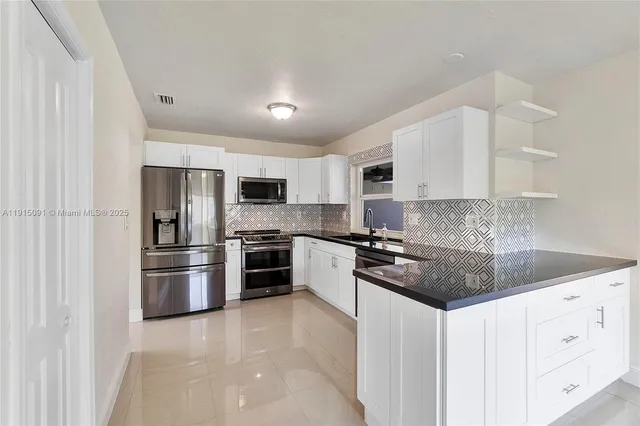 a kitchen with stainless steel appliances granite countertop a refrigerator sink and stove