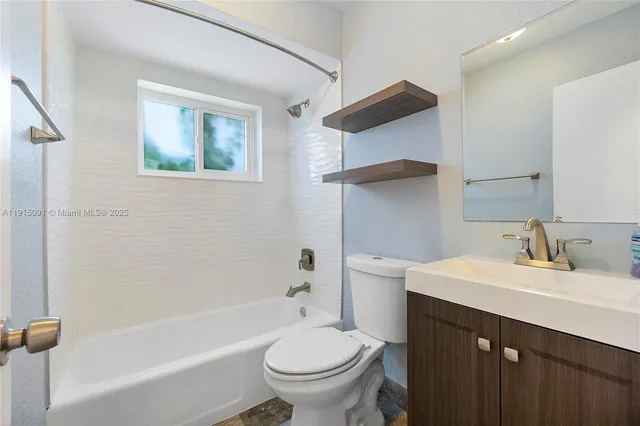a bathroom with a sink toilet vanity and tub