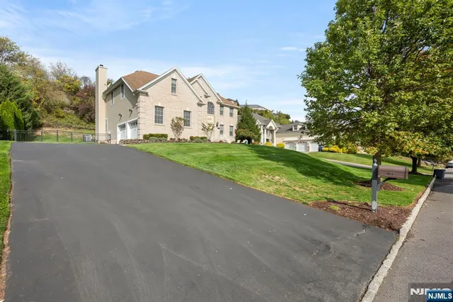 a view of a house with a yard and large trees