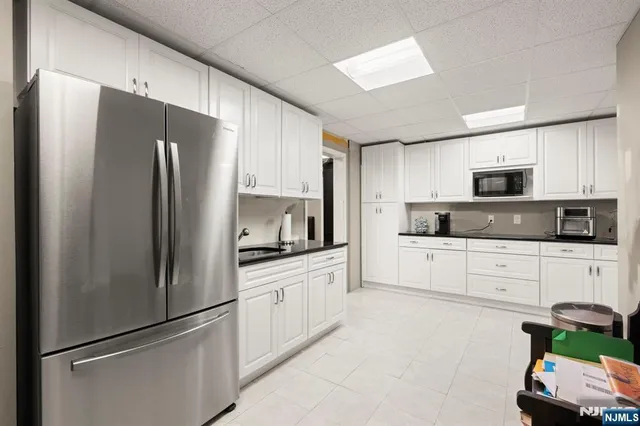 a kitchen with stainless steel appliances a refrigerator sink and microwave