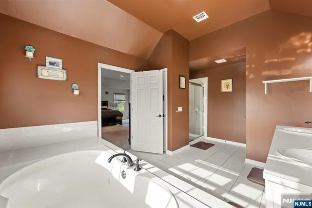 a spacious bathroom with a double vanity sink and mirror