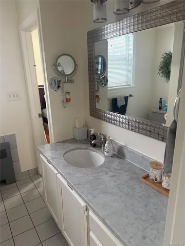 a bathroom with a granite countertop sink and a mirror