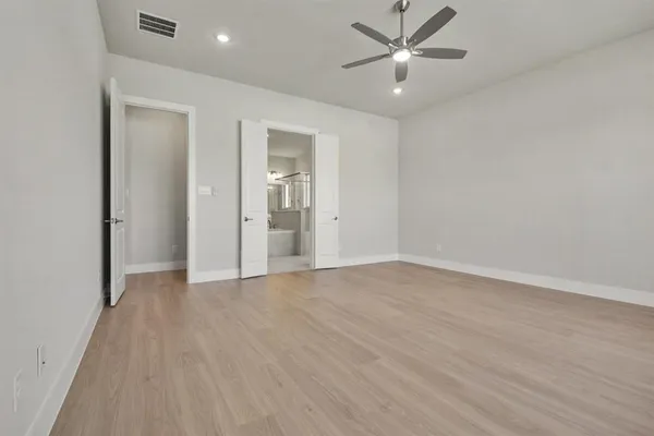 an empty room with chandelier fan and closet area