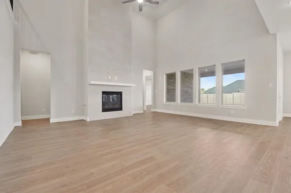 a view of an empty room with a fireplace and a window