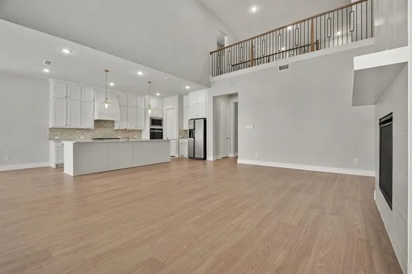 a large kitchen with stainless steel appliances granite countertop a large counter top a sink and a refrigerator