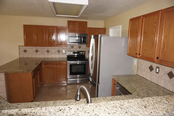 a kitchen with stainless steel appliances granite countertop a refrigerator stove and oven