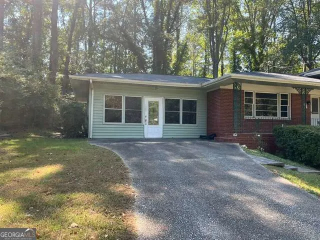 a view of a house with backyard and trees