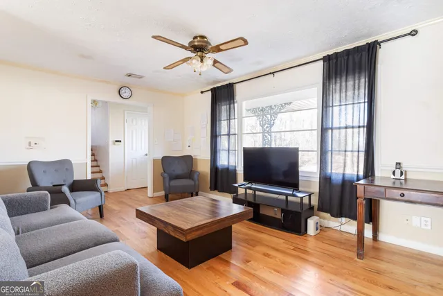 a living room with furniture a window and a wooden floor