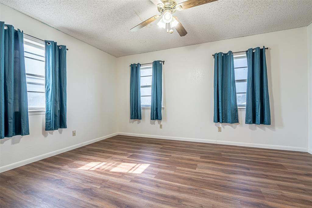 501 Endora Dublin, TX 76446 - Photo 22 of 39 a view of an empty room with wooden floor and a window