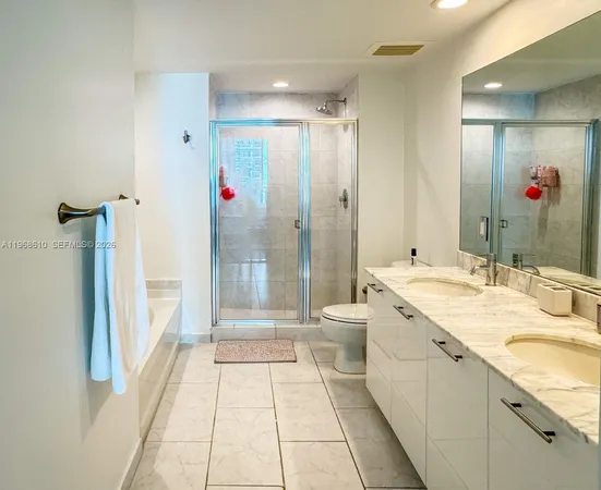 a bathroom with a tub sink shower and mirror