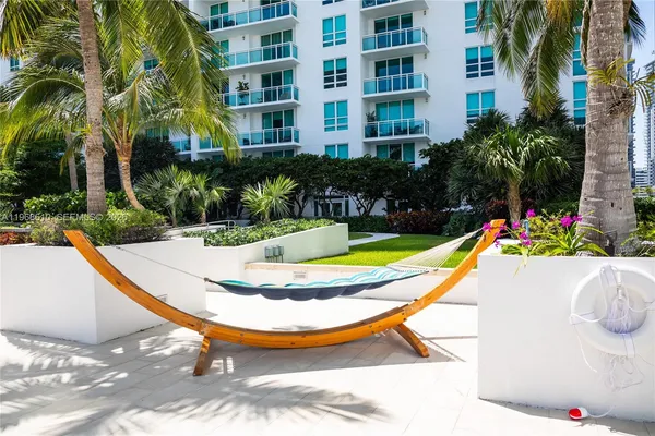a view of swimming pool with a lounge chair and palm trees
