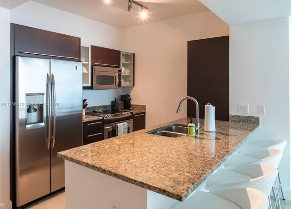 a kitchen with stainless steel appliances granite countertop a refrigerator and a sink