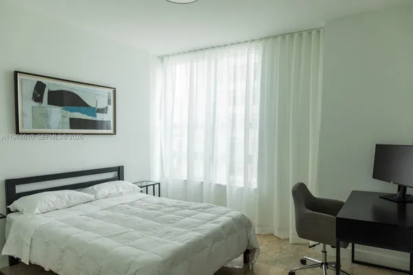 a bedroom with a bed and chair