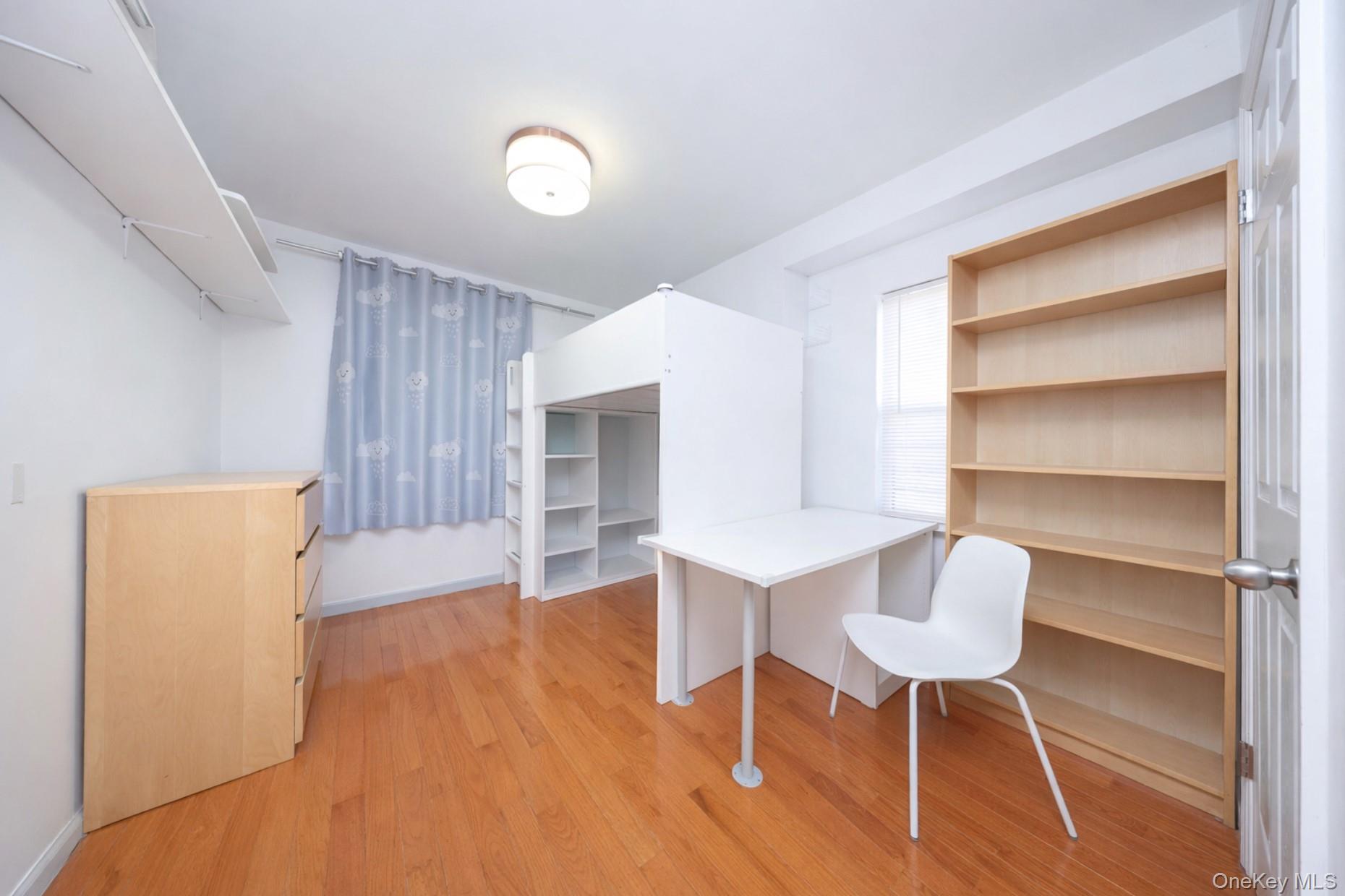 48-01 216th Street Queens, NY 11364 - Photo 11 of 14 a room with wooden floor and chair