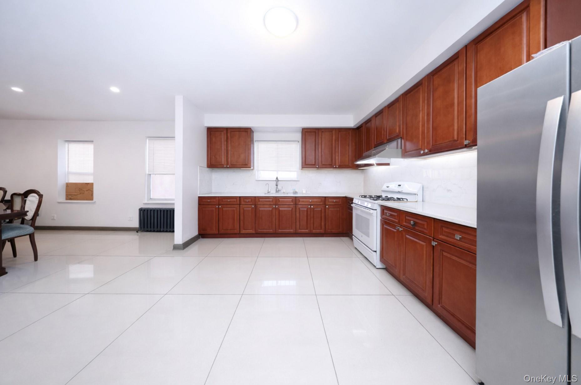48-01 216th Street Queens, NY 11364 - Photo 6 of 14 a large kitchen with stainless steel appliances granite countertop a refrigerator and a stove top oven