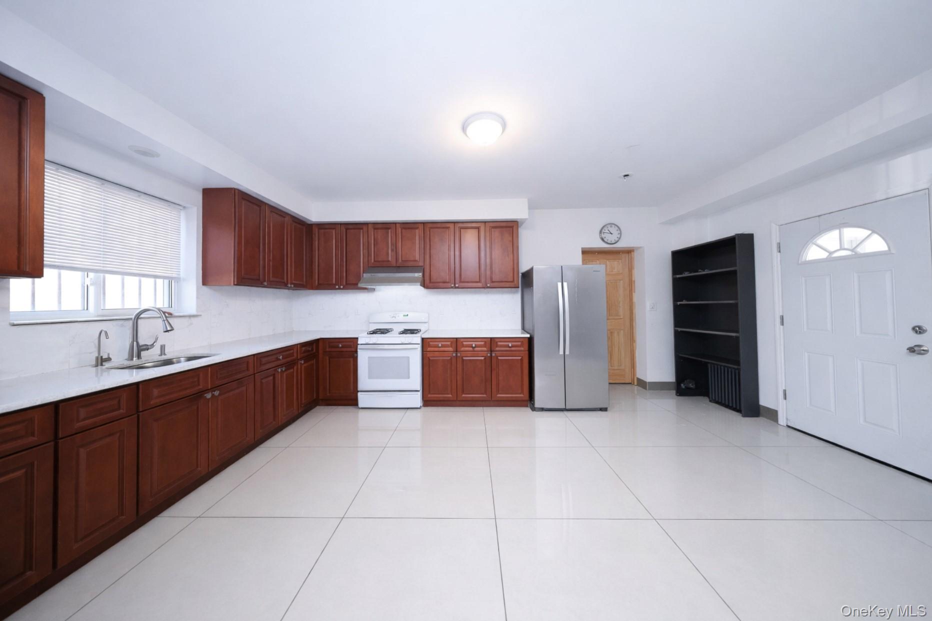 48-01 216th Street Queens, NY 11364 - Photo 7 of 14 a large kitchen with a large counter top stainless steel appliances and cabinets