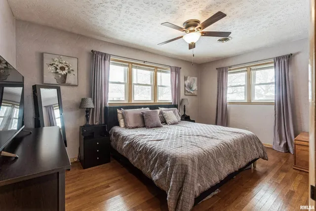 a bedroom with a large bed and a chandelier