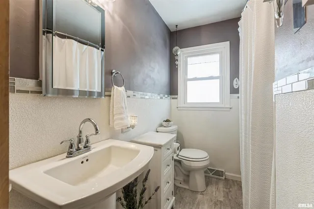 a bathroom with a sink a toilet and a mirror