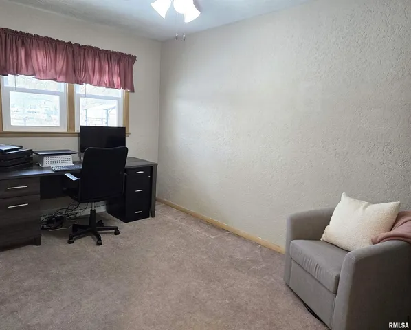 a livingroom with workspace and a window