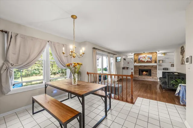 a living room with furniture a fireplace and a chandelier