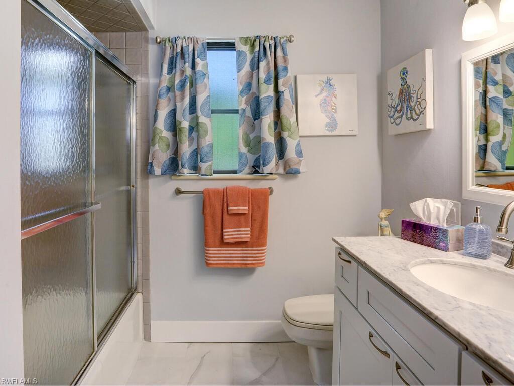 1014 Broad Avenue North Naples, FL 34102 - Photo 24 of 33 a bathroom with a granite countertop sink a toilet and shower