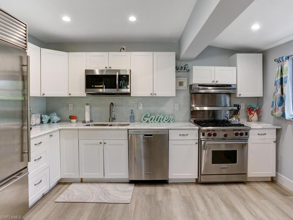 1014 Broad Avenue North Naples, FL 34102 - Photo 9 of 33 a kitchen with cabinets stainless steel appliances a sink and a stove