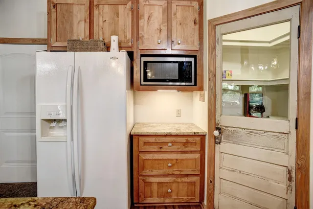 a kitchen with stainless steel appliances granite countertop a sink refrigerator and microwave