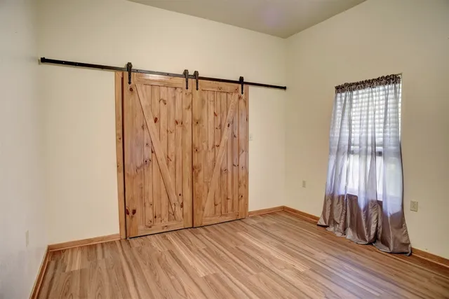 an empty room with wooden floor and a window
