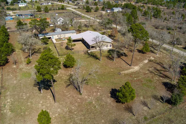 an aerial view of a house with a yard and lake view