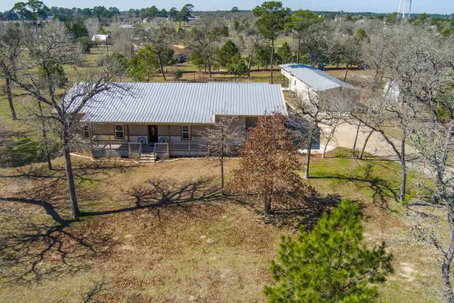 an aerial view of a house with a yard basket ball court and outdoor seating