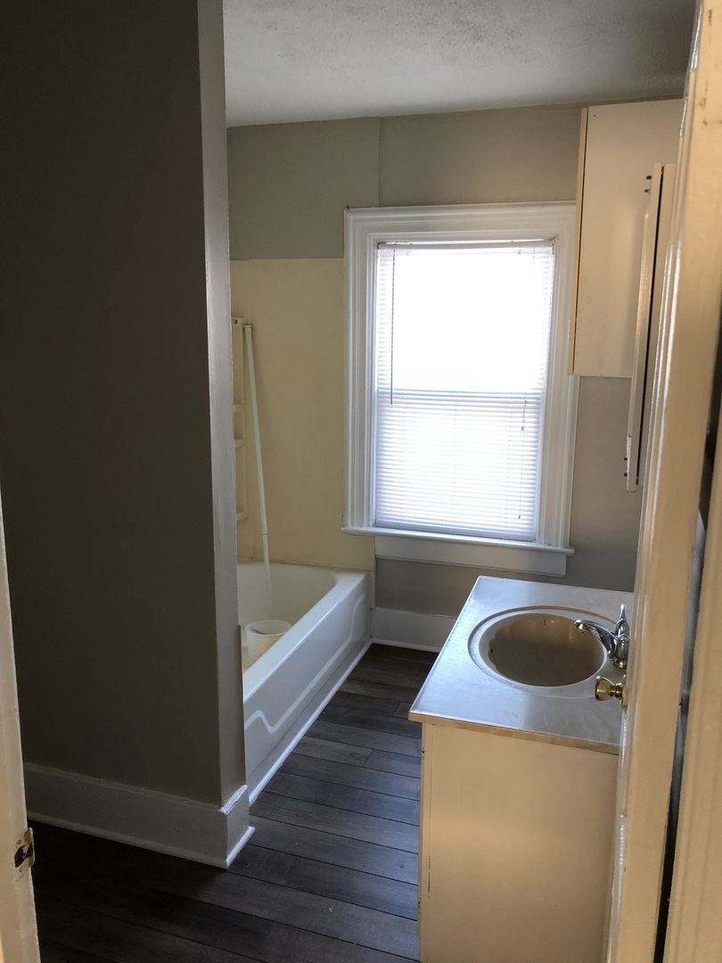 5420 West Main Street Monee, IL 60449 - Photo 6 of 16 a bathroom with a tub a sink and a window