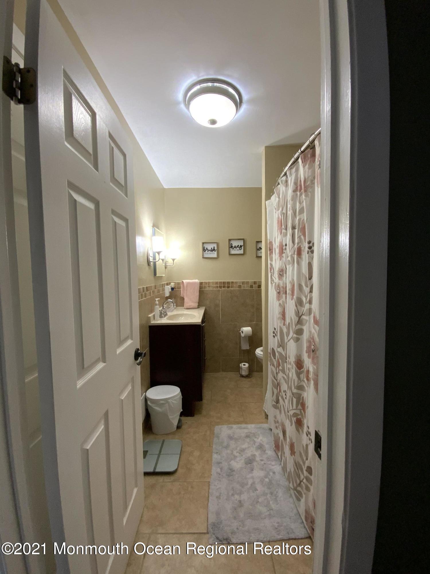 151 Ravine Drive Matawan, NJ 07747 - Photo 15 of 23 a bathroom with a toilet sink and shower curtain