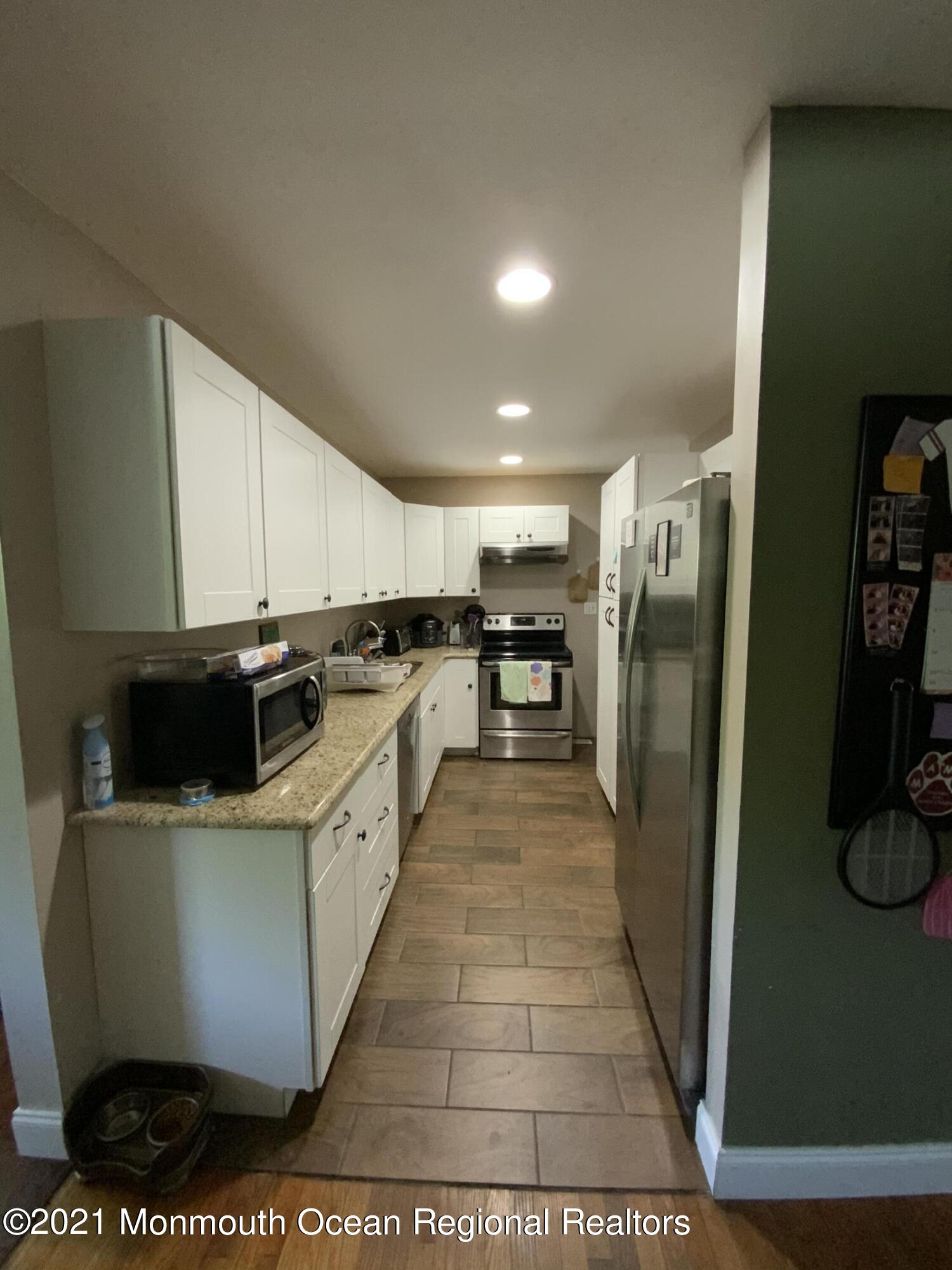 151 Ravine Drive Matawan, NJ 07747 - Photo 8 of 23 a large kitchen with stainless steel appliances kitchen island granite countertop a refrigerator and a stove