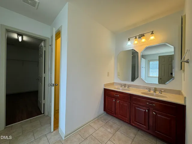 a spacious bathroom with a double vanity sink and a mirror