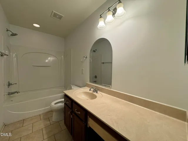 a bathroom with a granite countertop sink a toilet and bathtub