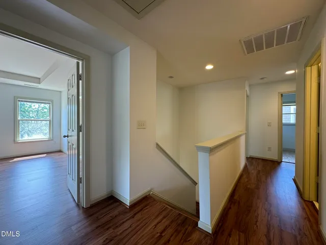 a view of a hallway with wooden floor