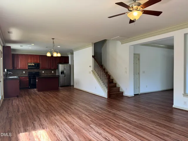 a view of a room with wooden floor and a ceiling fan