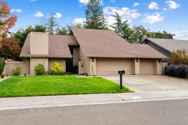 a front view of a house with a garden and garage