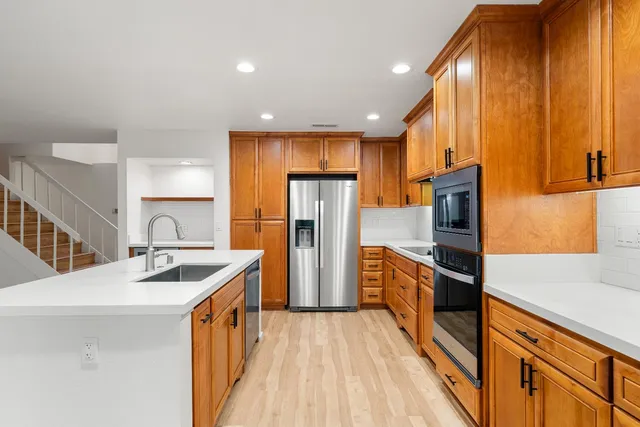 a kitchen with stainless steel appliances granite countertop a sink stove and refrigerator