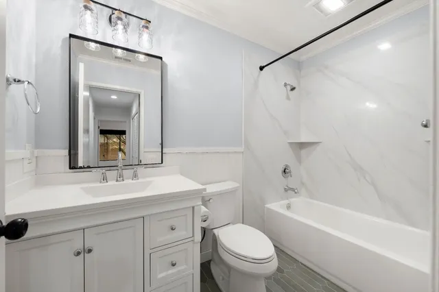 a bathroom with a sink toilet vanity and shower