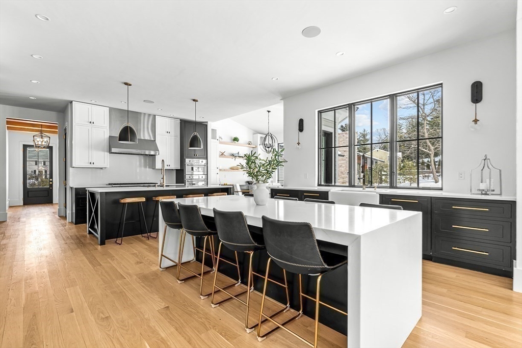 54 Johnson Road Winchester, MA 01890 - Photo 10 of 42 a kitchen with stainless steel appliances granite countertop a stove a refrigerator a sink a dining table and chairs with wooden floor
