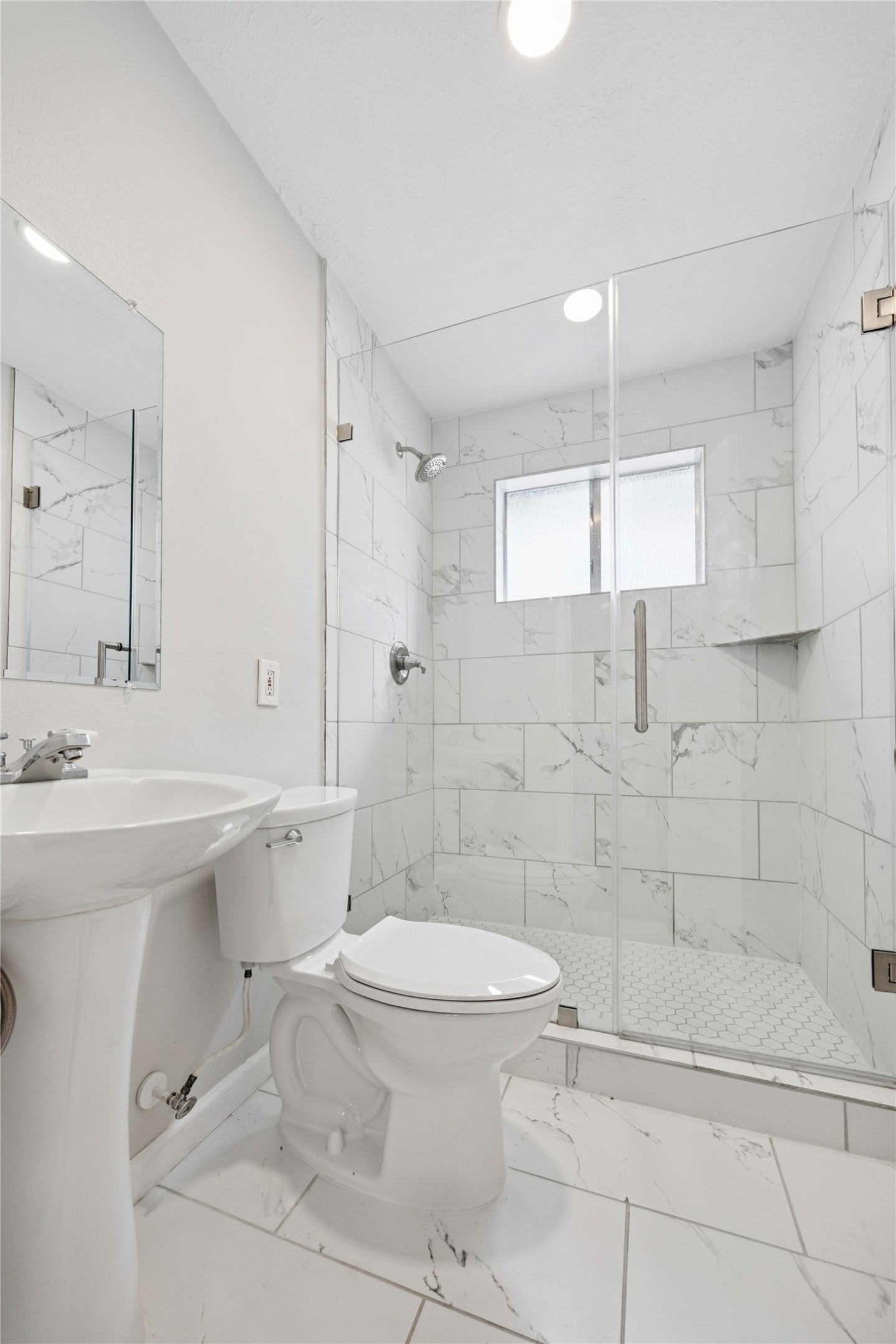 2614 Cleburne Street Houston, TX 77004 - Photo 12 of 22 A pedestal sink and a modern, glass-enclosed shower maximize the footprint in this bathroom with clean lines and sharp design.
