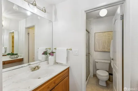 a bathroom with a granite countertop sink toilet and shower