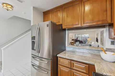 a kitchen with granite countertop a refrigerator and a sink