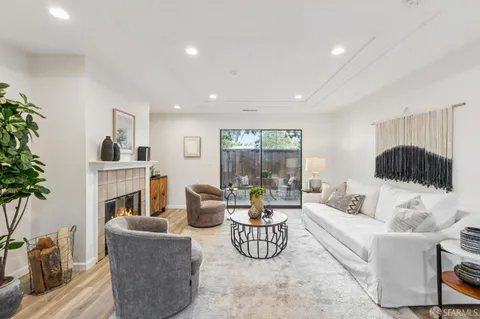 a living room with furniture a fireplace and a potted plant