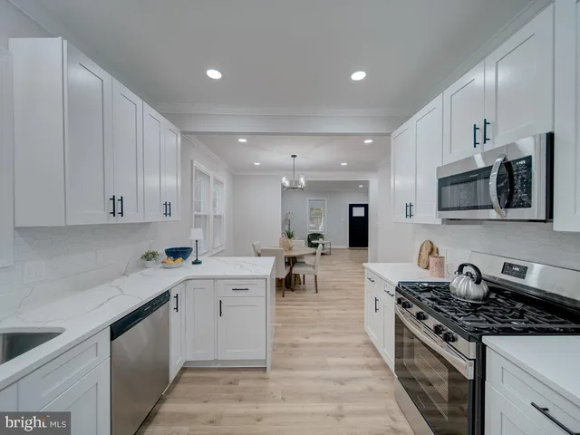 a kitchen with a sink stove top oven and cabinets
