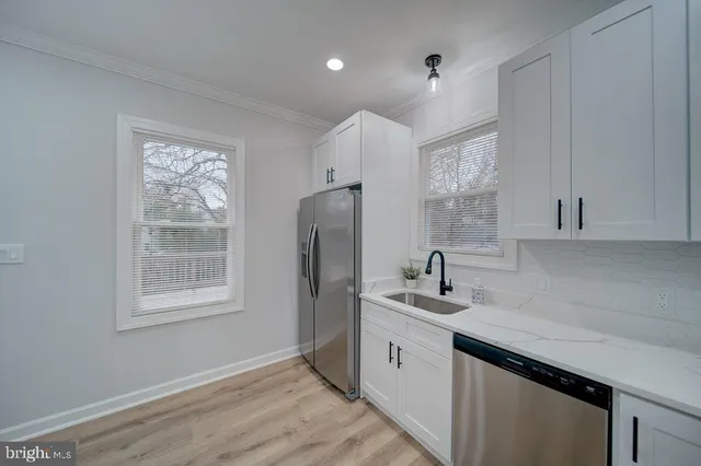 a kitchen with a sink window and cabinets