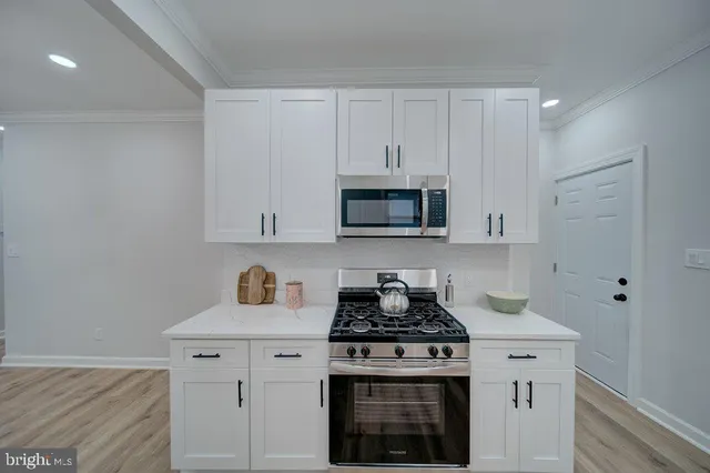 a kitchen with white cabinets and stainless steel appliances