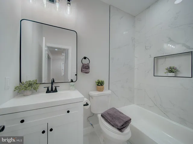 a bathroom with a bathtub sink and mirror